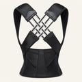 Black adjustable back posture corrector on a warm neutral studio background