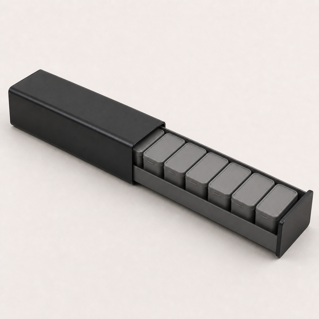 WeekVault aluminum shell open with seven removable day compartments visible